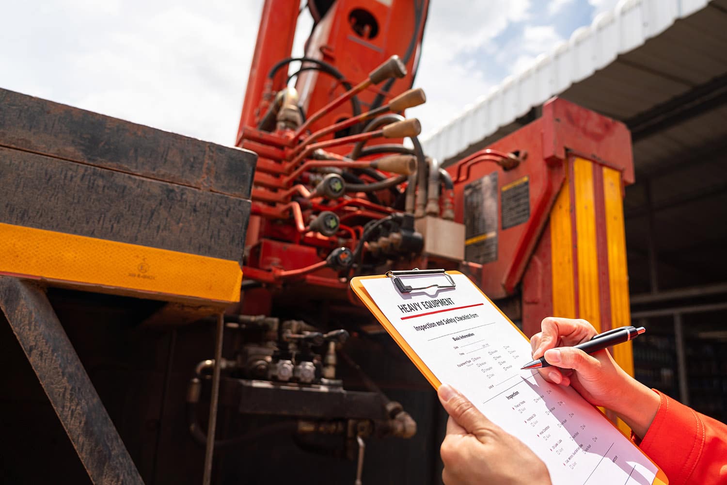 A mechanical engineer is inspecting the condition of truck crane vehicle (as blurred background) before start the operation on the inspection checklist form. Industrial working with safety practive.